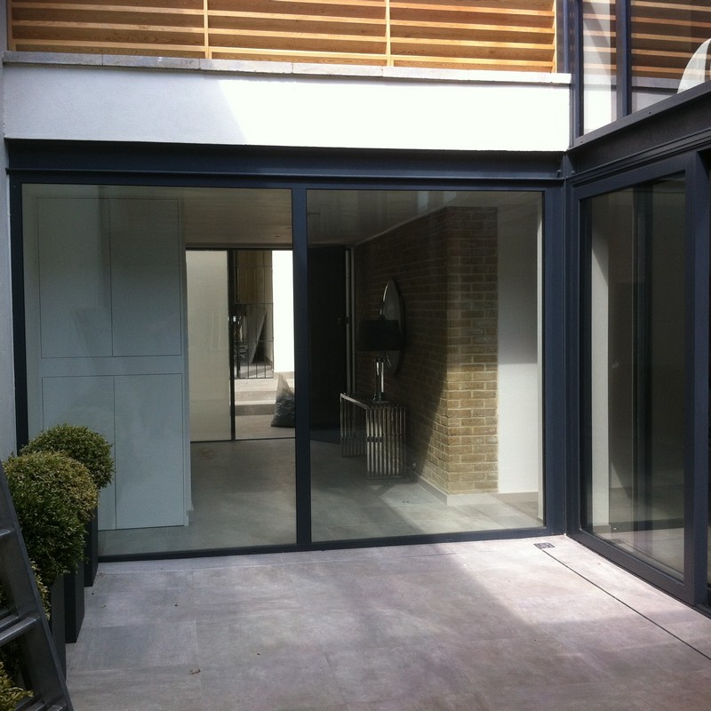 Floor-to-ceiling sliding doors opening to courtyard in Iver