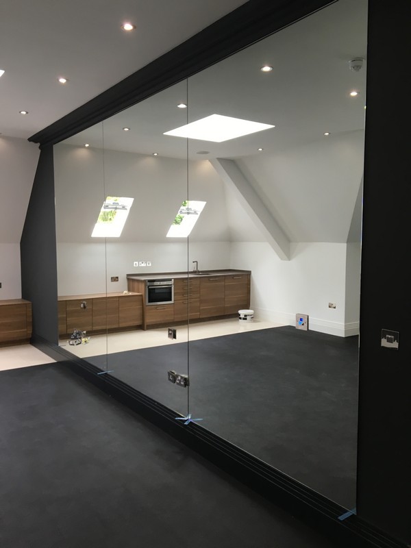 Frameless glass partition in loft conversion by Iver glaziers