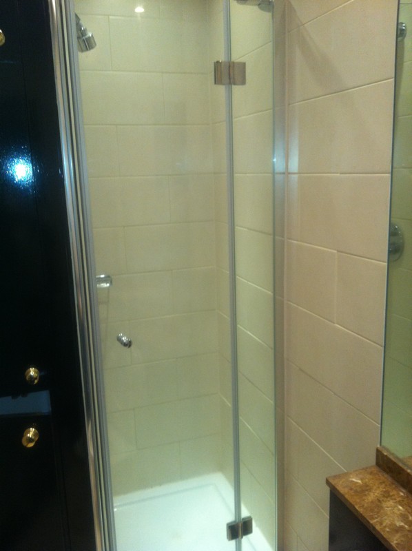 Frameless glass shower enclosure with chrome fittings in Iver