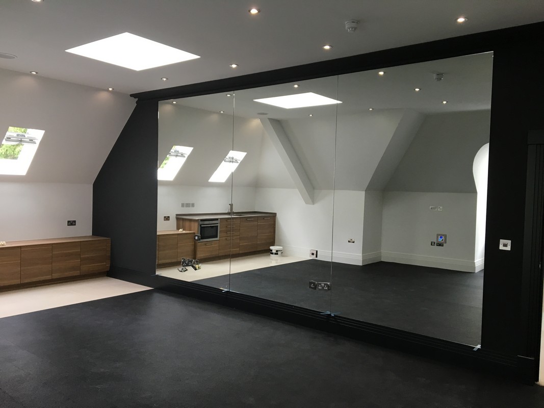 Frameless glass wall dividing loft conversion in Iver
